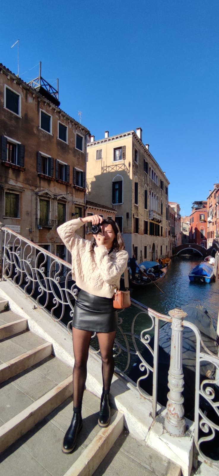 Alexa is taking a picture on a bridge in Venice, Italy.