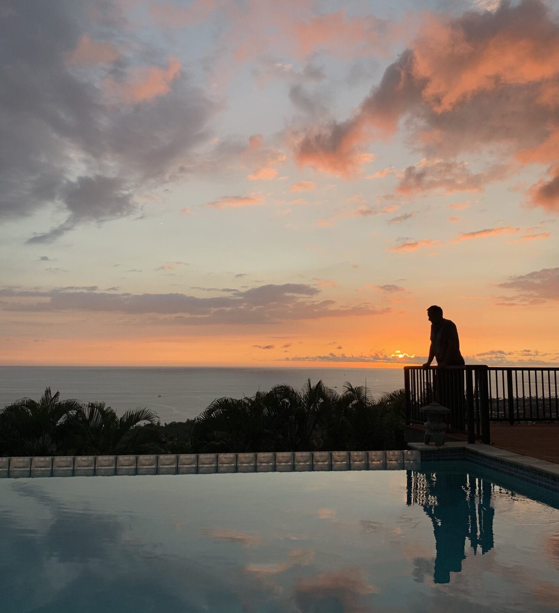 A man standing at the edge of a pool at sunset, contemplating life's mysteries while harnessing inner strength to overcome personal challenges.