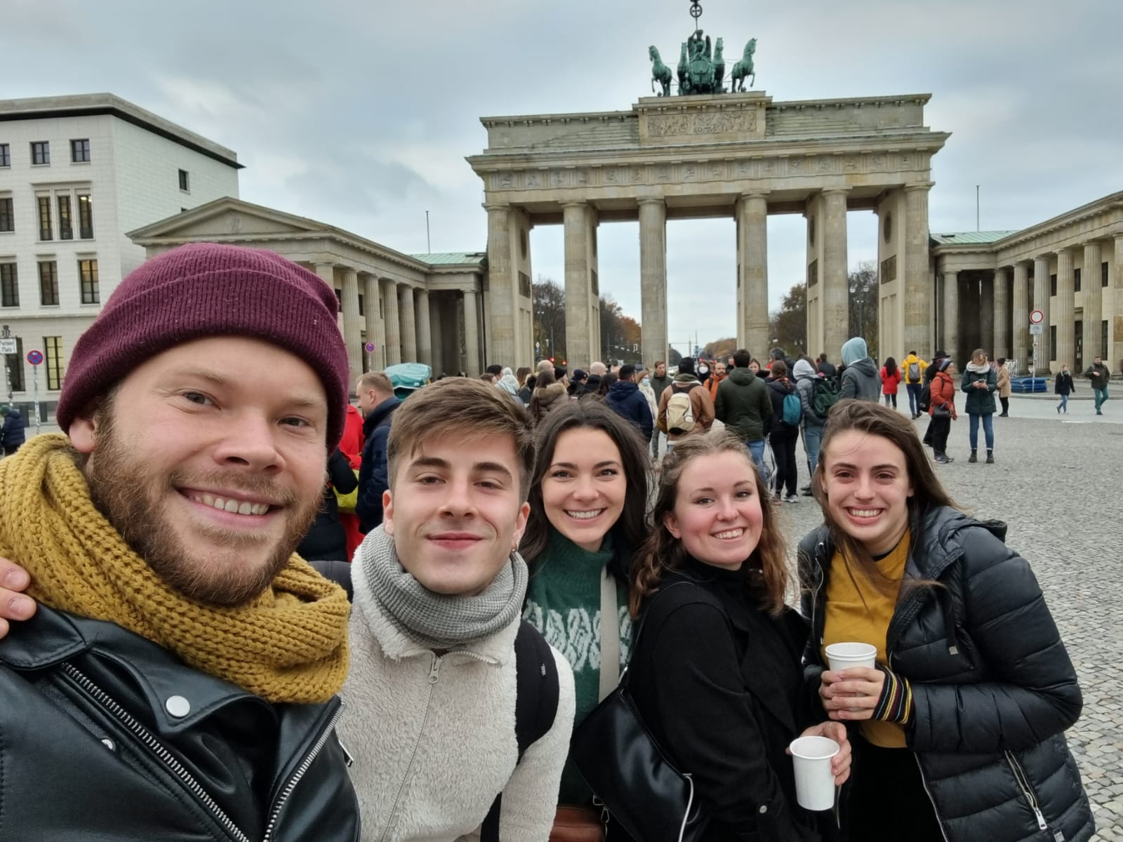 A solo female traveler posing for a photo in front of the Brandenburg Gate in Germany.