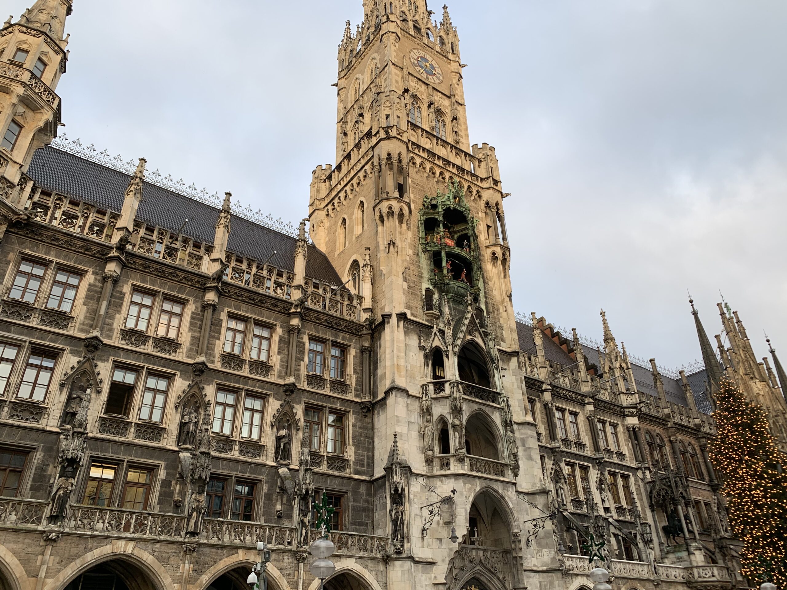 A solo female traveler exploring an ornate building with a clock tower in the background during her journey through Germany.