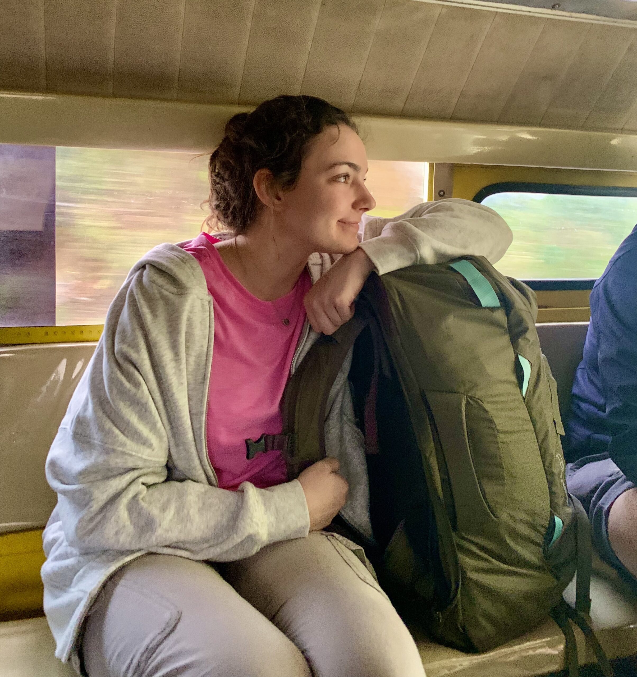 Two people sitting on a train during their first days of solo travel, with backpacks.