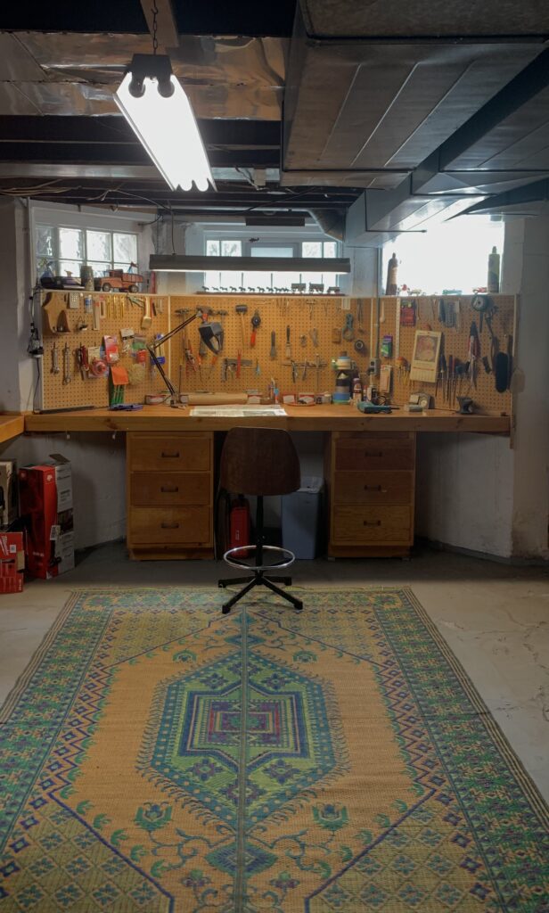 A room with a desk and a rug.