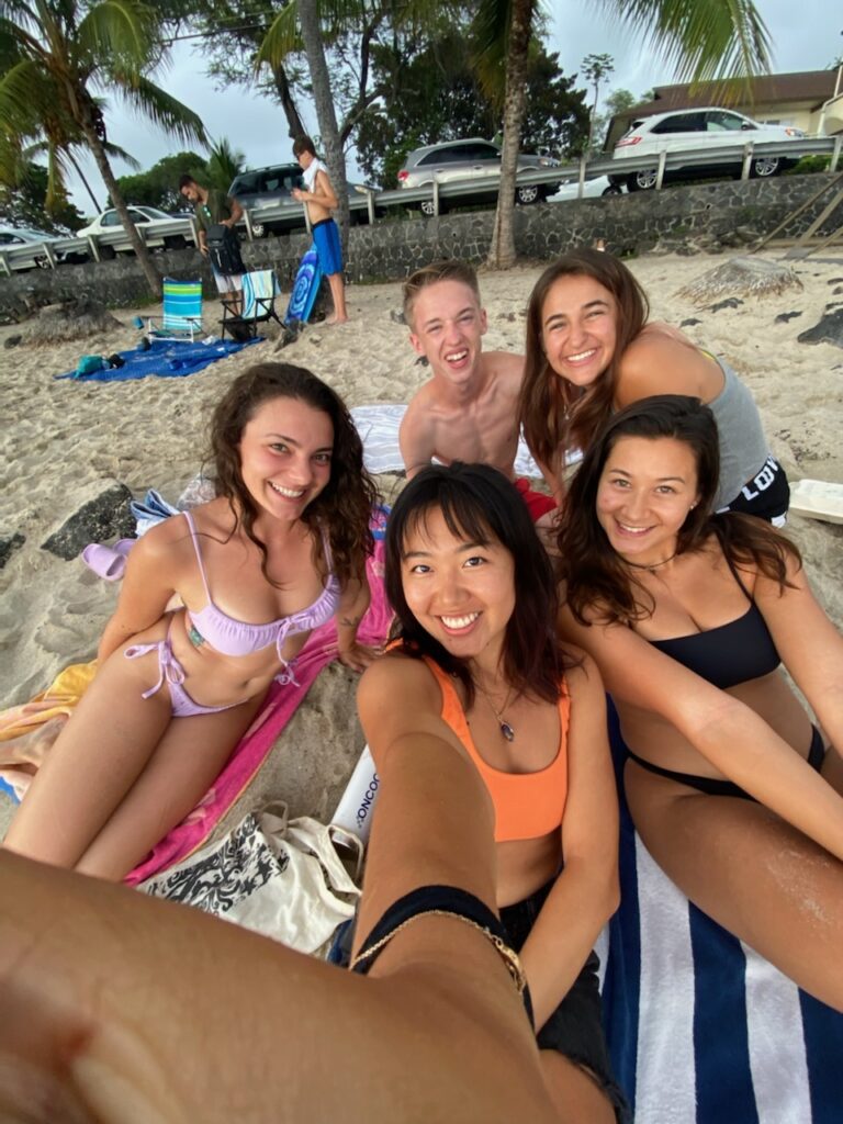 A group of people taking a selfie on the beach.