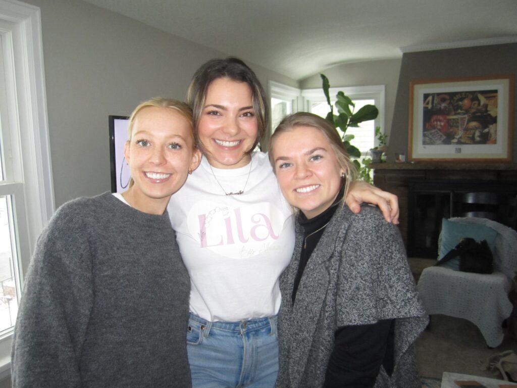 Three women posing for a photo in a living room.